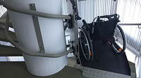 Plattformlift Artira im Treppenhaus mit Rollstuhl auf der Plattform